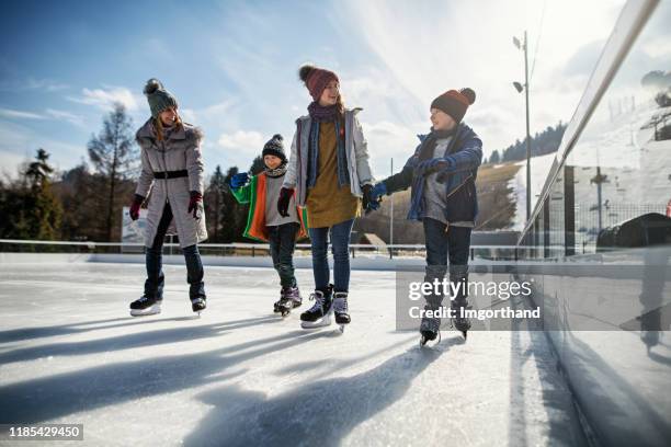 familie genießt gemeinsam eislaufen - family sport winter stock-fotos und bilder