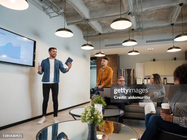 jonge latijnse man geven presentatie in coworking ruimte - in front of stockfoto's en -beelden