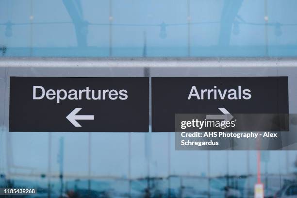 airport departures and arrivals outdoor signage in the rain - anzeigetafel stock-fotos und bilder