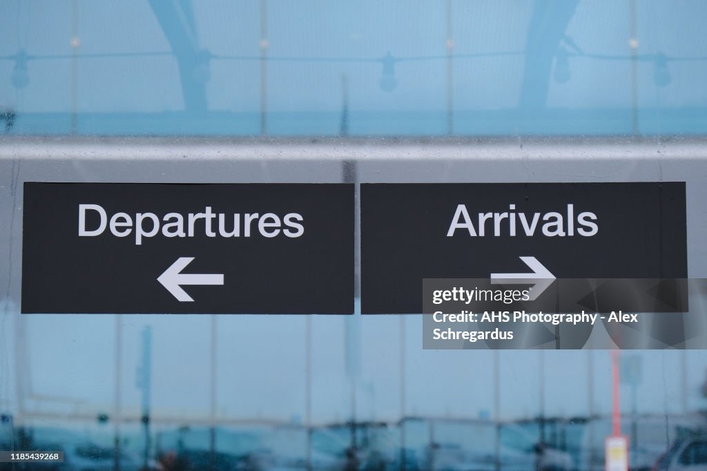 Airport departures and arrivals outdoor signage in the rain