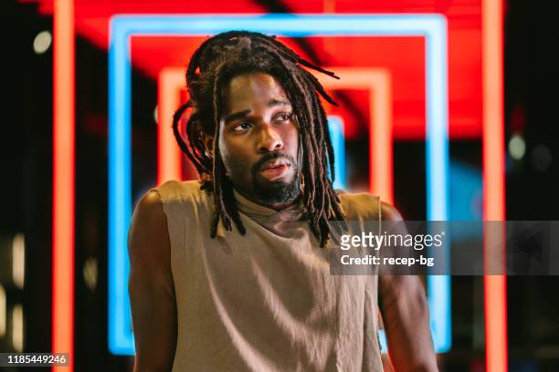 portrait of handsome black man in front of colorful neon lights - musician stock pictures, royalty-free photos & images