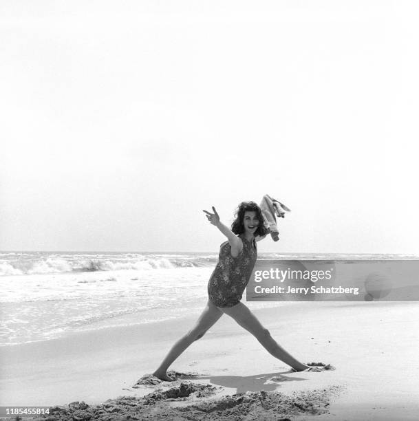 American model Carmen Dell'Orefice, in a swimsuit, poses with her arms wide on Long Island's Jones Beach, New York, May 9, 1958.