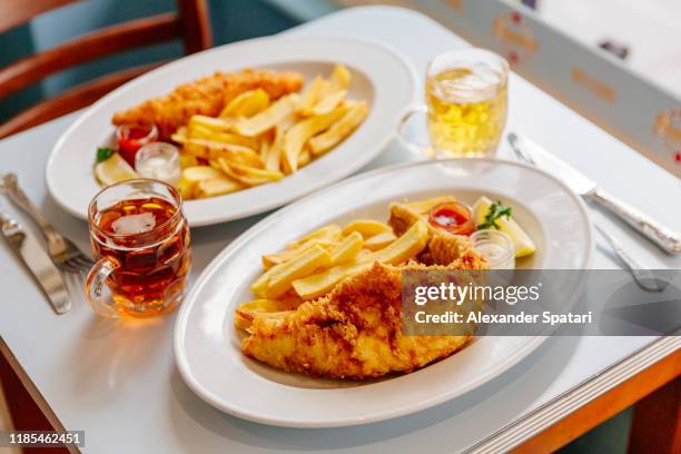 fish and chips on plate and beer served on the table - merluza fotografías e imágenes de stock