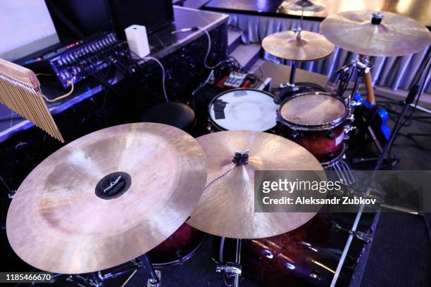 close up of golden bronze cymbal plate part of drum set out of focus instrument parts in background - rock music logo stock pictures, royalty-free photos & images
