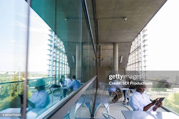 diverse medical professionals work on hospital balcony - hospital exterior stock pictures, royalty-free photos & images