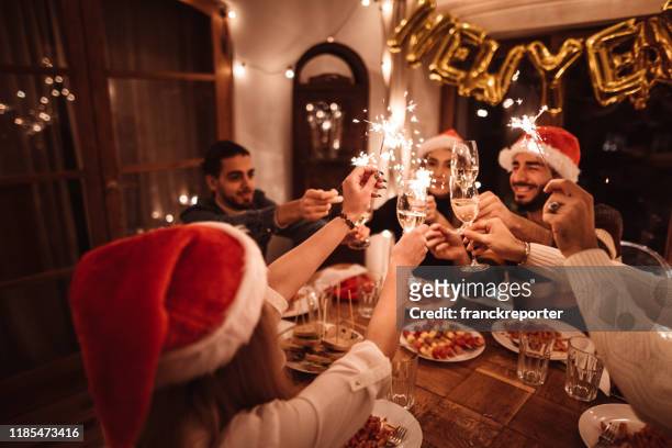 friends toasting at home for christmas - new year's eve dinner stock pictures, royalty-free photos & images