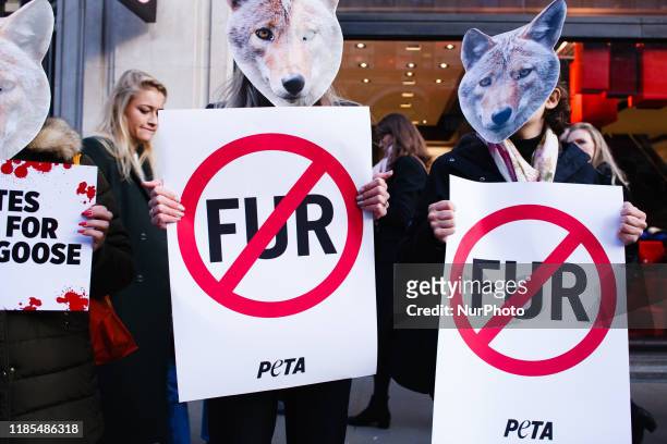 Animal rights activists holding PETA placards demonstrate against the use of real fur by clothing retailer Canada Goose outside the company's store...