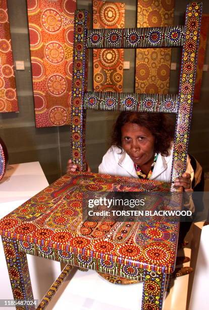 Arrernte Aborigine Bridgette Wallace displays an elborately painted chair entitled "Story Belonging to Women Dreaming" at the opening of the...