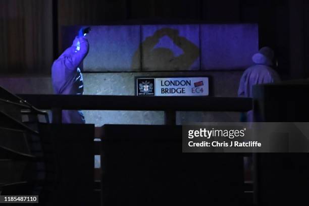 Forensic investigator takes photographs by London Bridge after a number of people are believed to have been injured after a stabbing, police have...