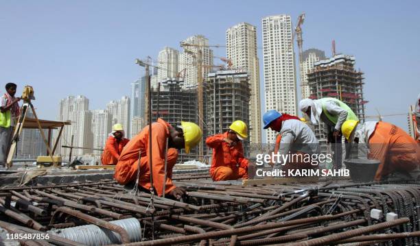 Asian workers are seen working at a construction site in the Gulf emirate of Dubai, 05 September 2007. The departure of tens of thousands of illegal...