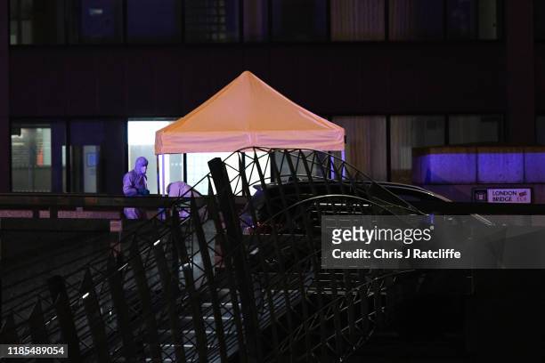 Forensic investigators examine the crime scene on London Bridge after a number of people are believed to have been injured after a stabbing, police...