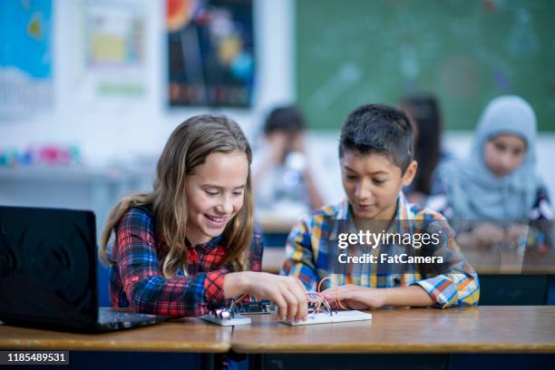 two multi-ethnic elementary students working on a stem project stock photo - pcb board stock pictures, royalty-free photos & images