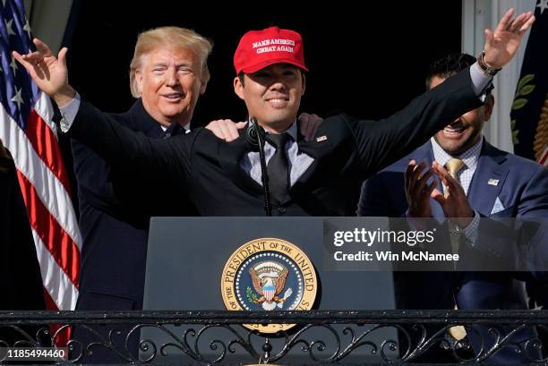 Catcher Kurt Suzuki wears a "Make America Great Again" hat as he is embraced by U.S. President Donald Trump as he welcomes the 2019 World Series...