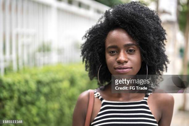 porträt einer schönen jungen frau in einer stadt - afro hairstyle stock-fotos und bilder