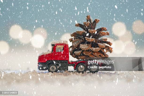 red truck with  pine cone - christmas truck stock pictures, royalty-free photos & images