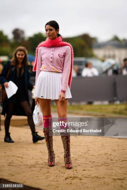 Guest wears a hot pink fluffy scarf, a light pink Dior long sleeves top, a Lacoste pleated mini skirt, hot pink and orange socks, brown and red...