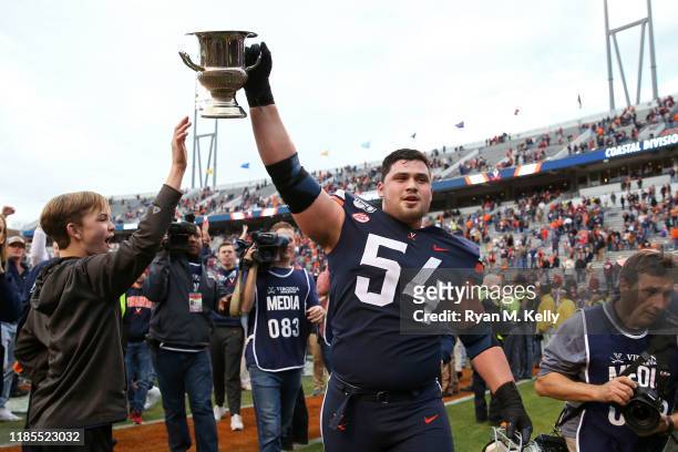 Ryan Nelson of the Virginia Cavaliers hoists the Commonwealth Cup after defeating the Virginia Tech Hokies during a game at Scott Stadium on November...