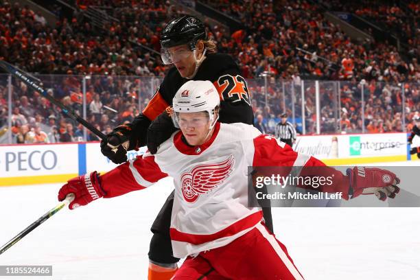 Dennis Cholowski of the Detroit Red Wings battles Oskar Lindblom of the Philadelphia Flyers in the second period at the Wells Fargo Center on...