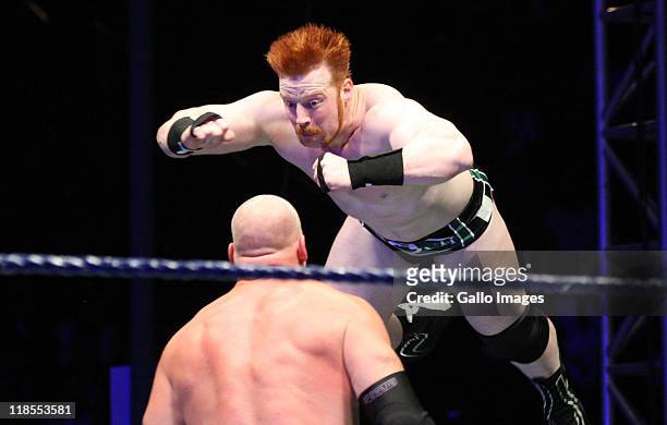 The Celtic Warrior Sheamus leaps towards the Big Red Monster Kane during the WWE Smackdown Live Tour at Westridge Park Tennis Stadium on July 08,...
