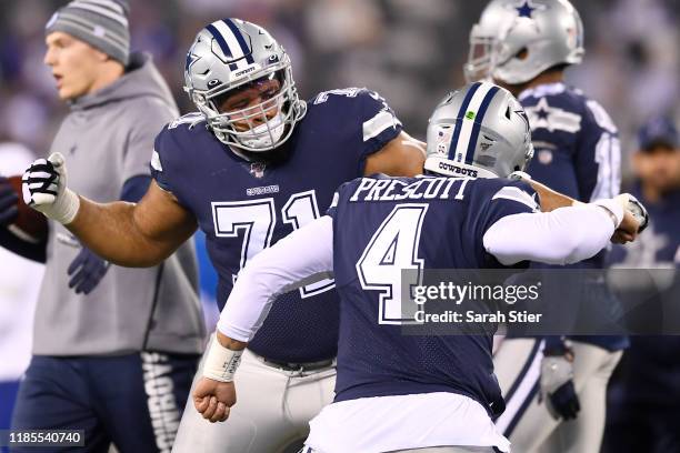 Dak Prescott of the Dallas Cowboys high-fives La'el Collins during warmups against the New York Giants at MetLife Stadium on November 04, 2019 in...