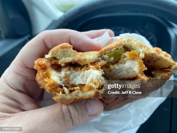 spicy chicken sandwich being consumed - sliced pickles stockfoto's en -beelden