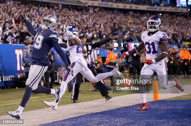 Amari Cooper of the Dallas Cowboys celebrates his touchdown in the fourth quarter as Corey Ballentine and Michael Thomas of the New York Giants...