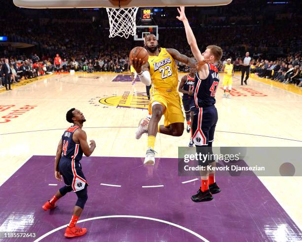 LeBron James of the Los Angeles Lakers drives to the basket against Davis Bertans and Ish Smith of the Washington Wizards during the first half at...