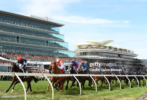 Hugh Bowman riding Twilight Payment and Craig Williams riding Vow and Declare leads the field around the first bend in the Lexus Melbourne Cup during...