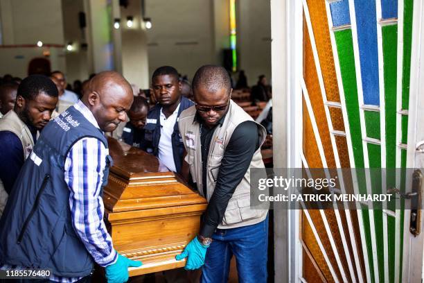 Men carry a coffin as family and colleagues of Belinda Kasongo who was part of the Ministry of Health vaccination team and was killed by armed men on...