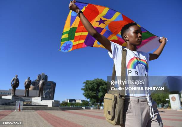 Woman holds a coloured flag as members and supporters of the lesbian, gay, bisexual, transgender take part in the first Botswana Pride Parade in...