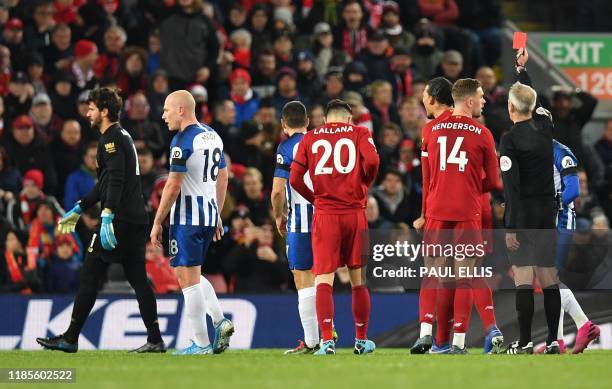 Referee Martin Atkinson shows a red card to Liverpool's Brazilian goalkeeper Alisson Becker during the English Premier League football match between...