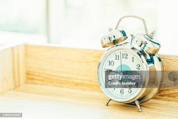 closeup alarm clock on wood table with free space. time concept. - alarm clock stock-fotos und bilder