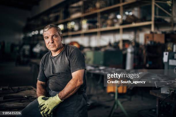 reifer mann allein in der fabrikwerkstatt - mechanic portrait stock-fotos und bilder
