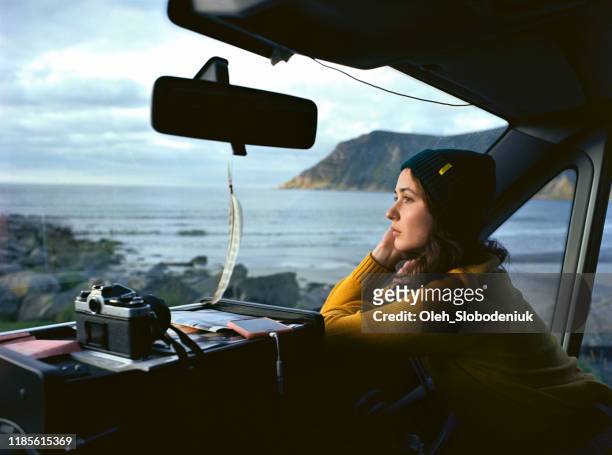 Woman looking at  beach on Lofoten islands from camper van