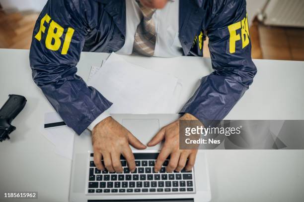 a senior fbi agent uses a laptop in the office - fbi stock pictures, royalty-free photos & images