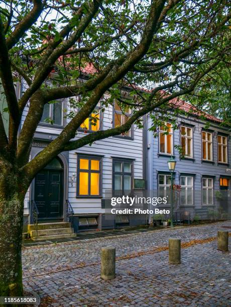 an evening scene along a characteristic stone alley in the historic center of bergen in western norway - autumn norway stock pictures, royalty-free photos & images