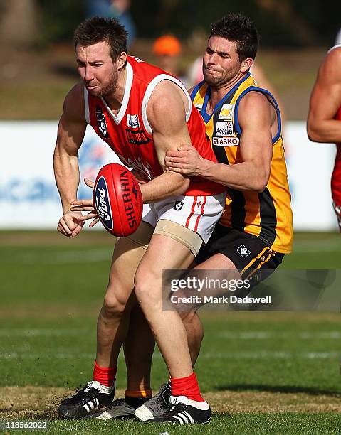 Brock McLean of the Bullants handballs as he is tackled during the round 15 VFL match between Sandringham and the Northern Bullants at Trevor Barker...