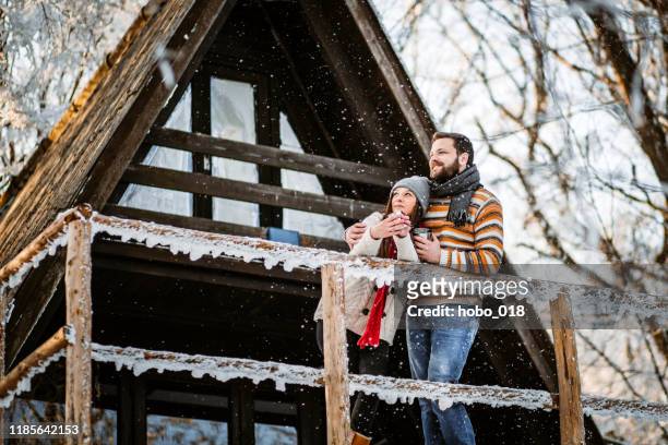 couple enjoys in their weedend home - winter cabin stock pictures, royalty-free photos & images