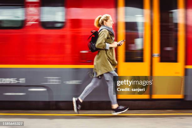 young woman running across the railroad station - catching train stock pictures, royalty-free photos & images