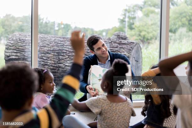 papá lee en la clase de su hijo - biblioteca infantil fotografías e imágenes de stock