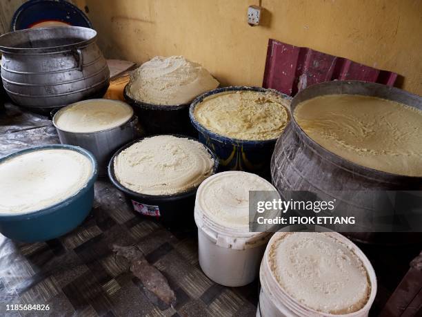 Processed shea butter is seen is metal pots and plastic containers at the Talba Shea Butter Village in Kodo on September 9, 2019. - Shea nuts grow...
