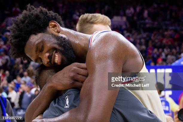 Joel Embiid of the Philadelphia 76ers embraces his former teammate T.J. McConnell of the Indiana Pacers at the Wells Fargo Center on November 30,...
