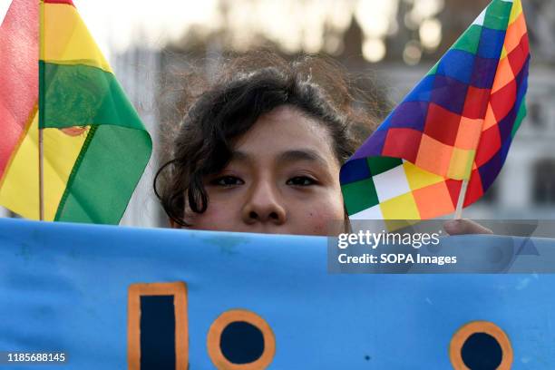 Protester holds the Bolivian and the Wiphala flags during the Rally. People gathered outside Downing Street to raise their voices against the coup in...