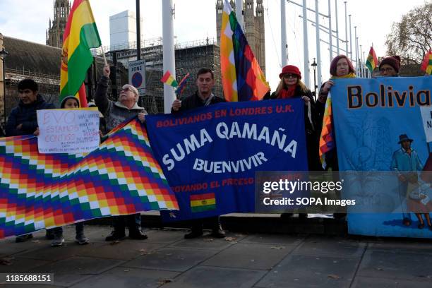 Protesters hold banners, Bolivian and Wiphala flags during the rally. People gathered outside Downing Street to raise their voices against the coup...