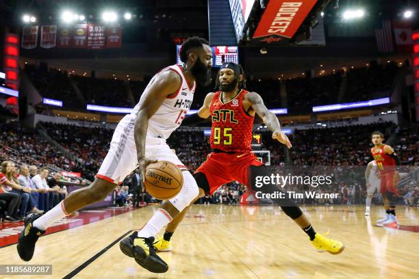 James Harden of the Houston Rockets drives to the basket defended by DeAndre' Bembry of the Atlanta Hawks in the first half at Toyota Center on...