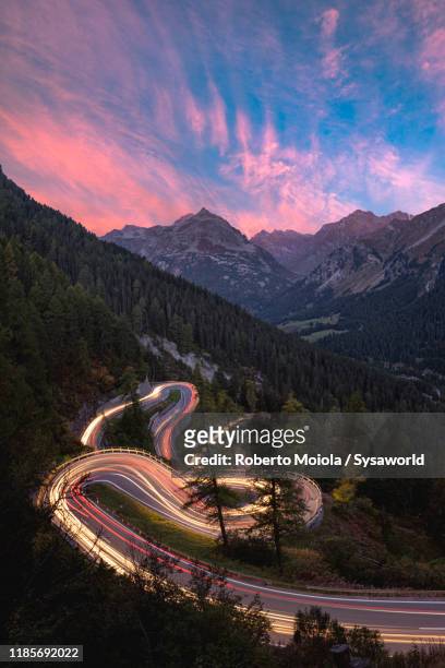 car trail lights on maloja pass mountain road, engadin, switzerland - região de maloja - fotografias e filmes do acervo