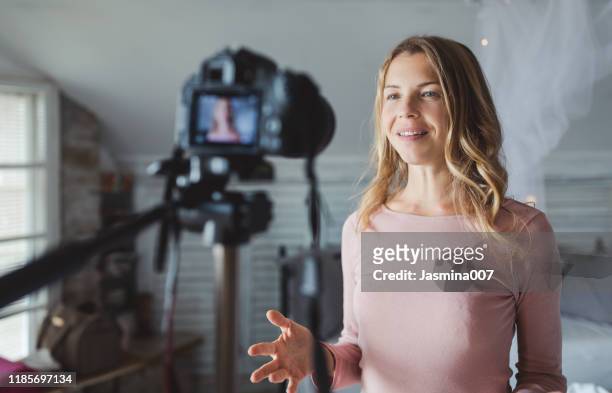 happy female vlogger live streaming from living room - youtuber stock pictures, royalty-free photos & images