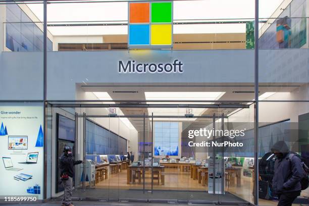 People walk past a Microsoft store entrance with the company's logo on top in midtown Manhattan at the 5th avenue in New York City, US, on 11...