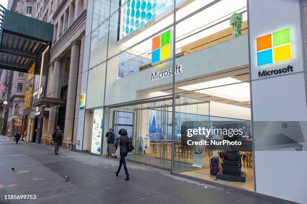 People walk past a Microsoft store entrance with the company's logo on top in midtown Manhattan at the 5th avenue in New York City, US, on 11...