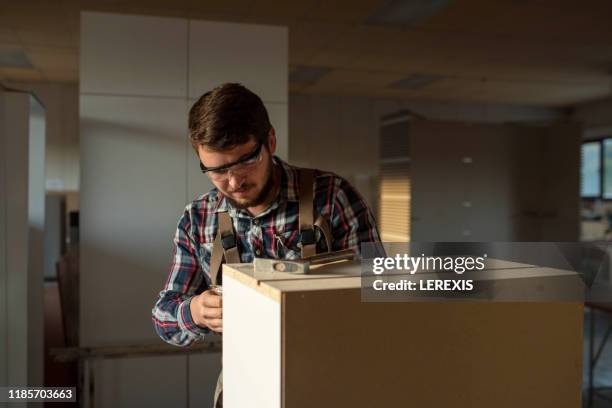 a carpenter repairs a kitchen cabinet - tournevis photos et images de collection